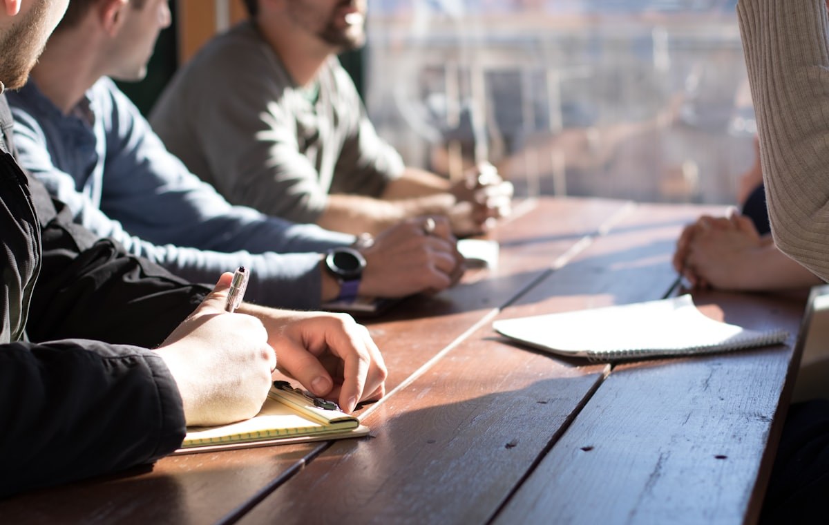 Petit groupe de collaborateurs en atelier autour d'une table de travail